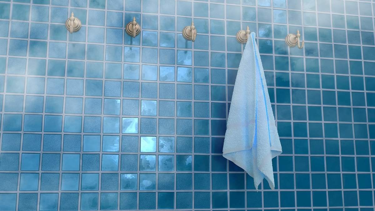 Carrelage bleu avec des robinets dorés et une serviette blanche pendue dessus