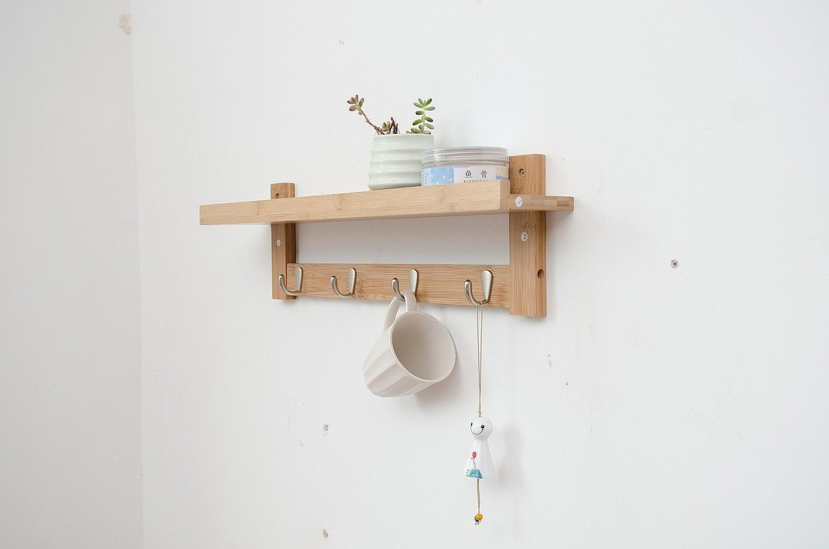 Étagère en bois fixée au mur avec crochets et objets décoratifs Étagère en bois fixée au mur avec crochets et objets décoratifs