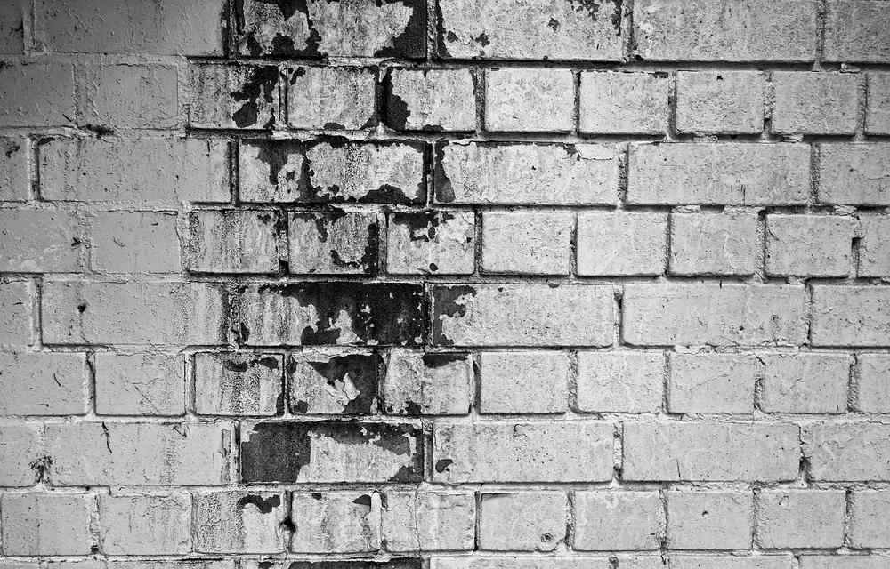 Mur en briques avec parties abîmées et taches sombres Mur en briques avec parties abîmées et taches sombres